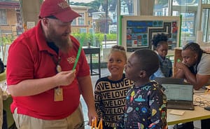 Man showing kids pencil
